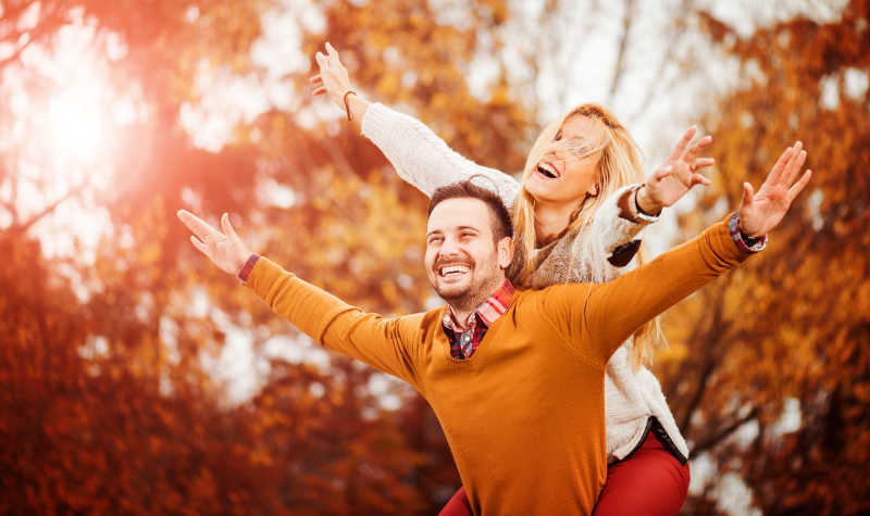 快乐的年轻夫妇在秋天公园里