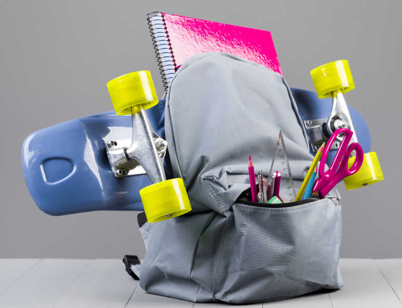 双肩包里的滑板和学习用品