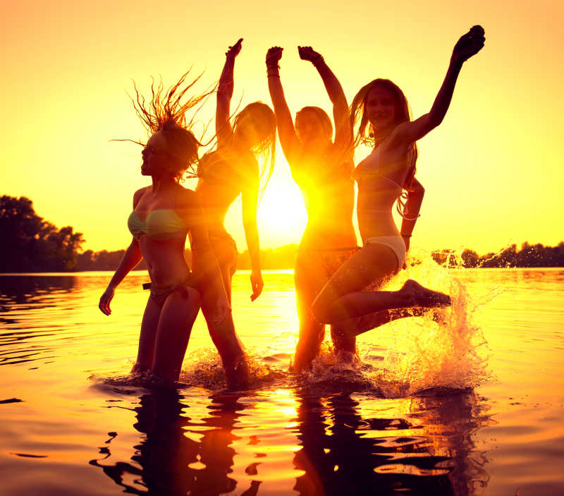一群美丽的女孩在美丽的夏日日落中翩翩起舞