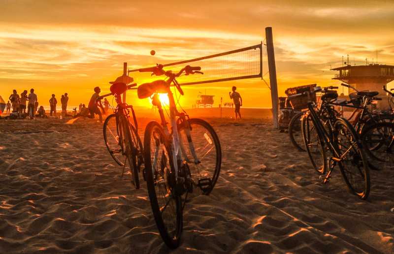 夕阳下停放在球网旁的自行车