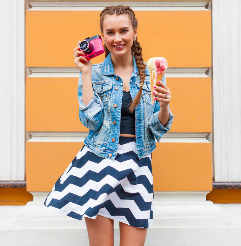 手拿相机与冰激凌的金发美女