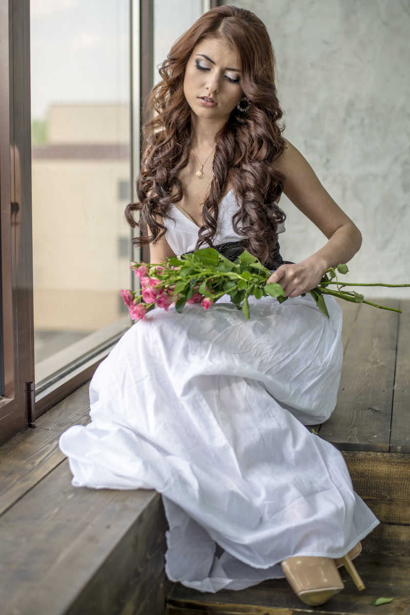 穿着白色长裙拿着花的美女