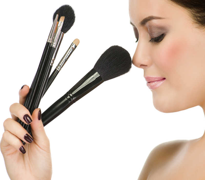 用化妆刷涂抹鼻尖的女孩