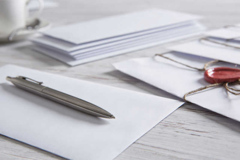 木桌上的信封和钢笔