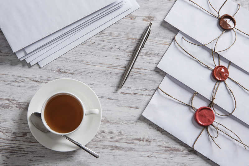 桌子上的信封和钢笔还有咖啡