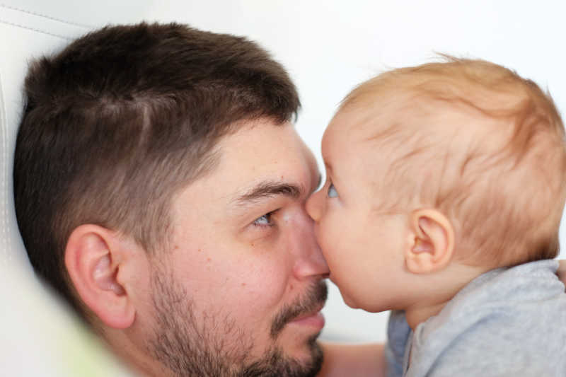 婴儿在亲吻父亲的鼻头