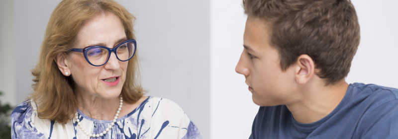 白色背景下女心理治疗师与她十几岁的病人坐在一起谈话