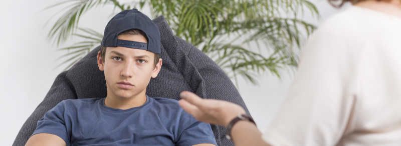 白色背景下坐在椅子上不开心的青少年