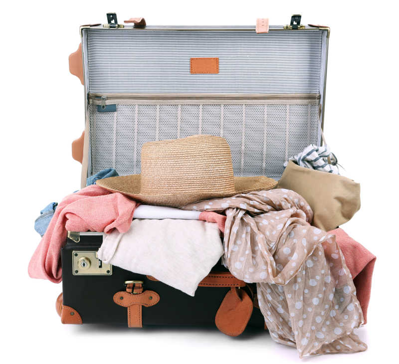 白色背景下手提箱里凌乱的行李