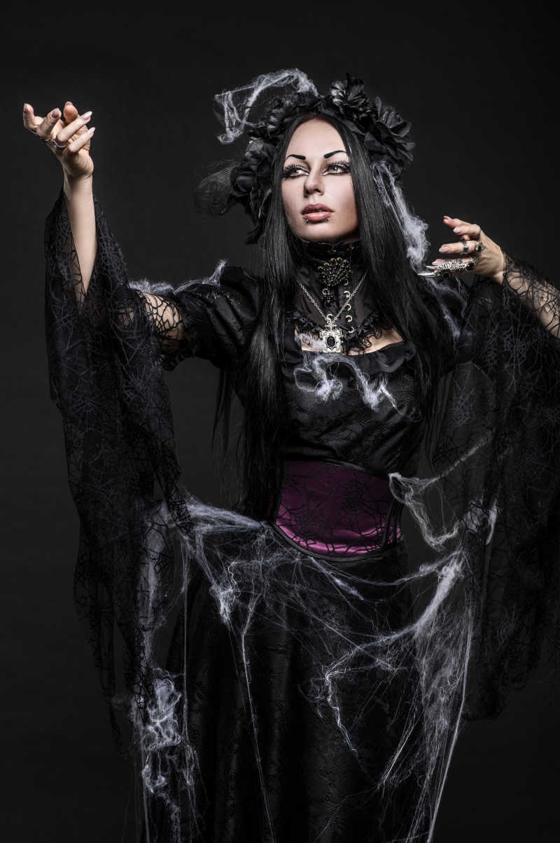 哥特式美女在黑暗的画室中穿着连衣裙