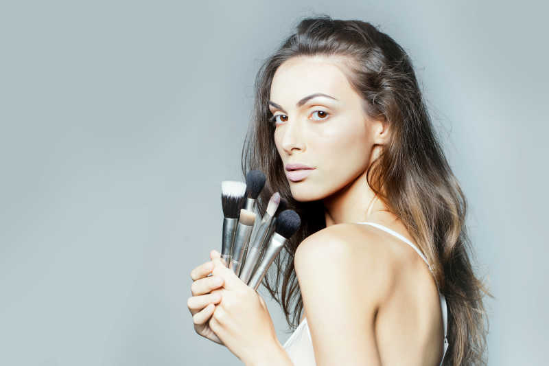 手拿化妆刷白色文胸的美女