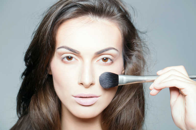 美女在用化妆刷化妆