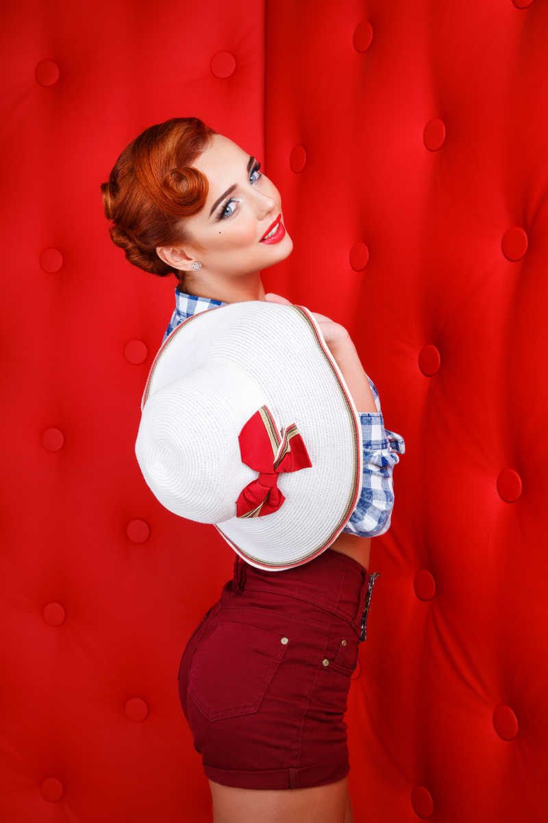 拿着白色帽子的蓝白色格子衬衫