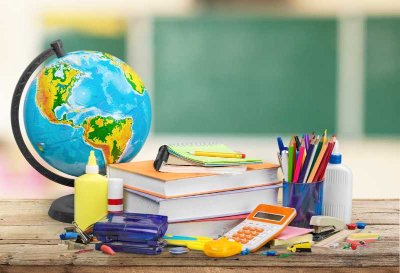 木桌上的各种学生用品和地球仪