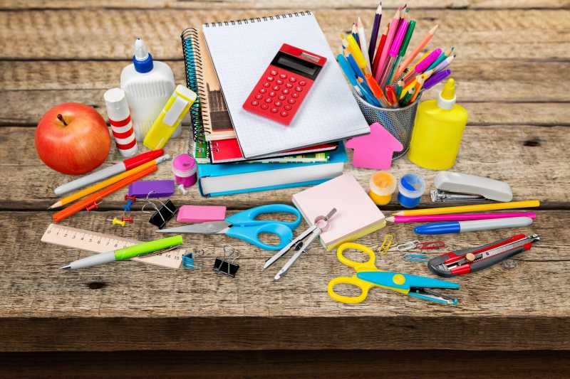 木桌上的各种学生用品和苹果