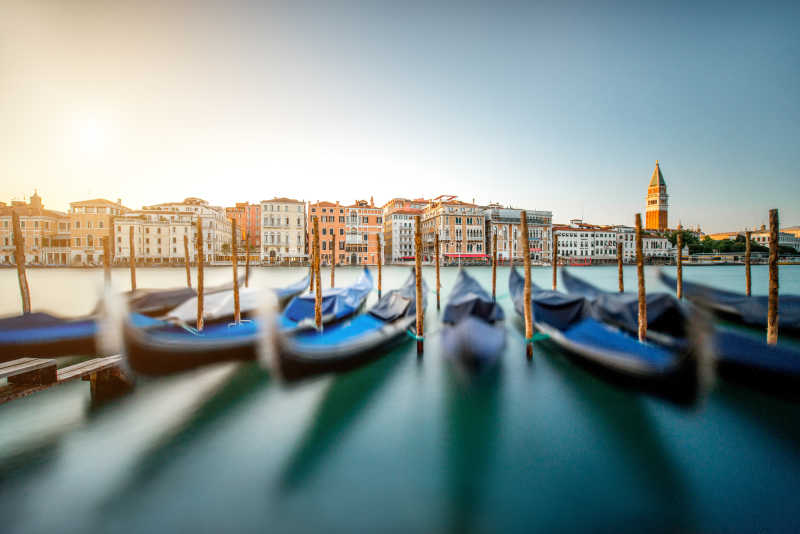 威尼斯哥特式建筑背景下运河上的停放整齐的小船