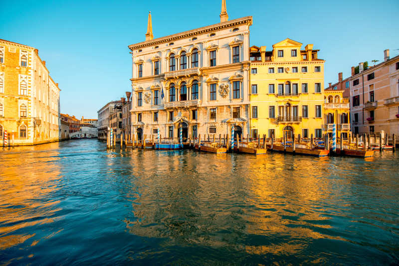 蓝天下格兰运河上五颜六色的哥特式建筑和小船