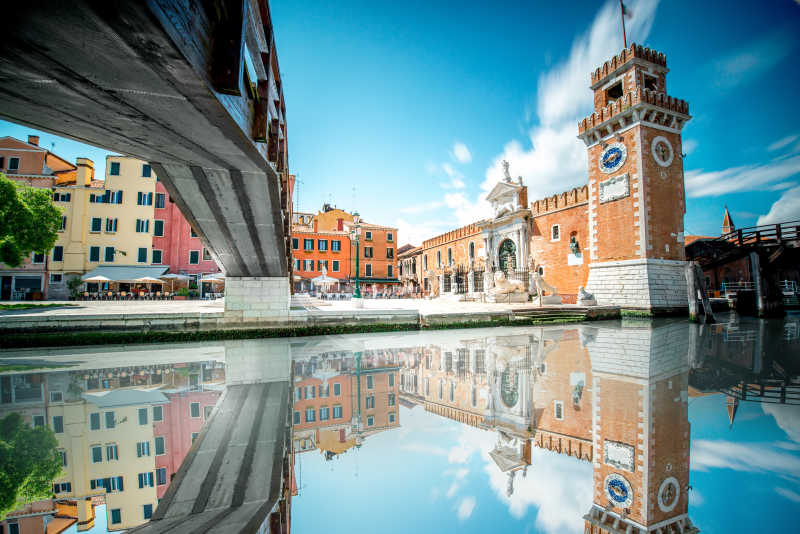蓝天白云背景下的威尼斯兵工厂和水中倒影