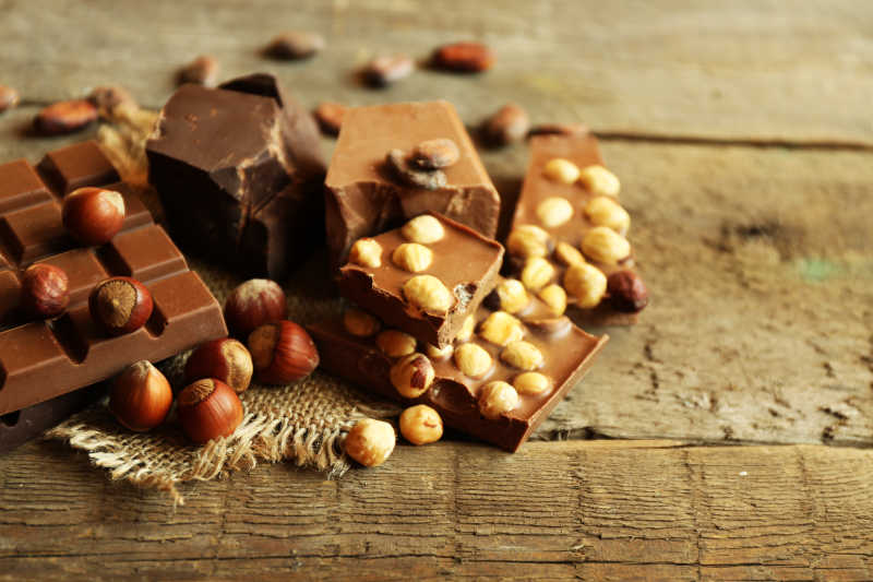  木质背景下的坚果和巧克力