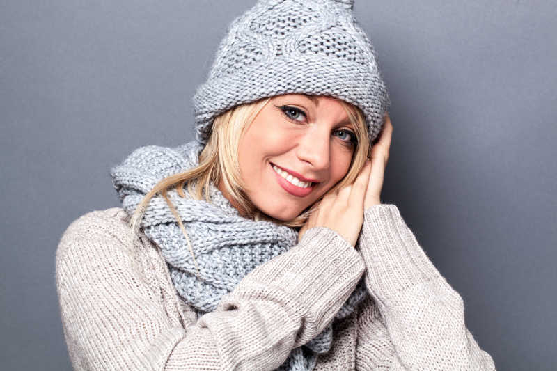 爱的年轻漂亮的金发女人用手势来表达冬天的舒适