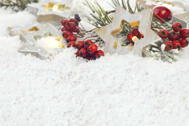 雪地上的圣诞节装饰品和红色果实