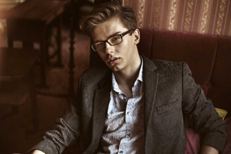 严肃优雅男孩坐在沙发上