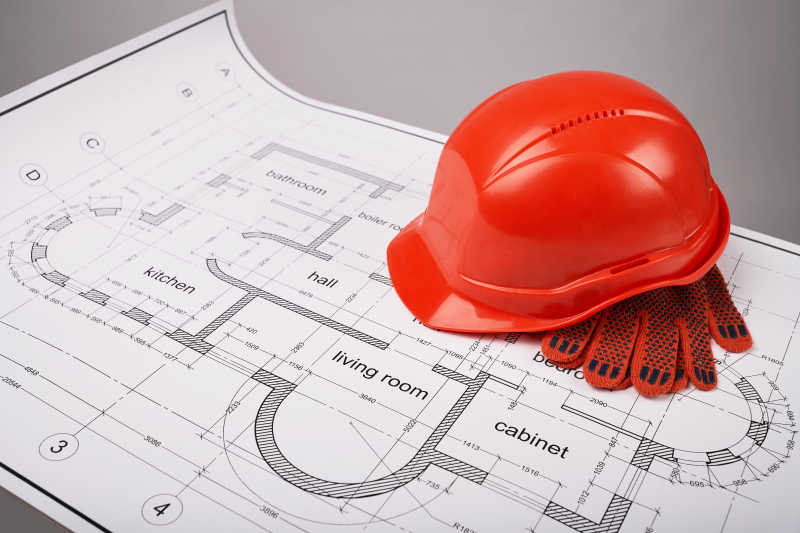 建筑图纸上的头盔和防护手套