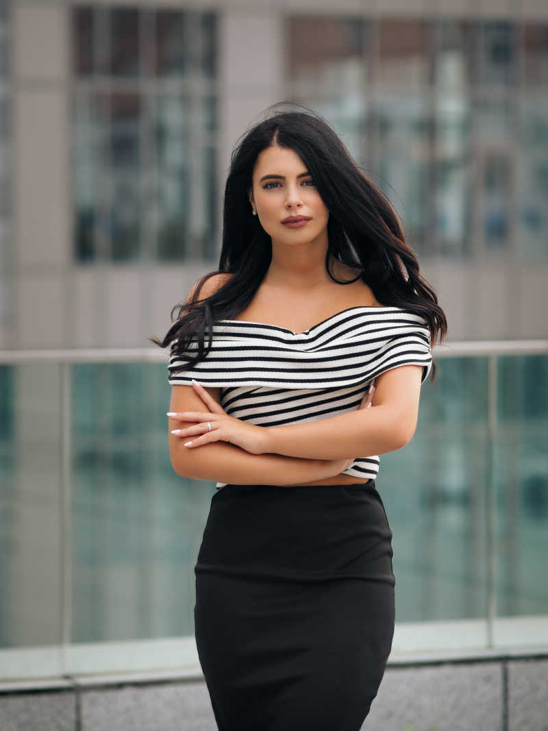 小桥上抱着胳膊站着的性感的黑发美女