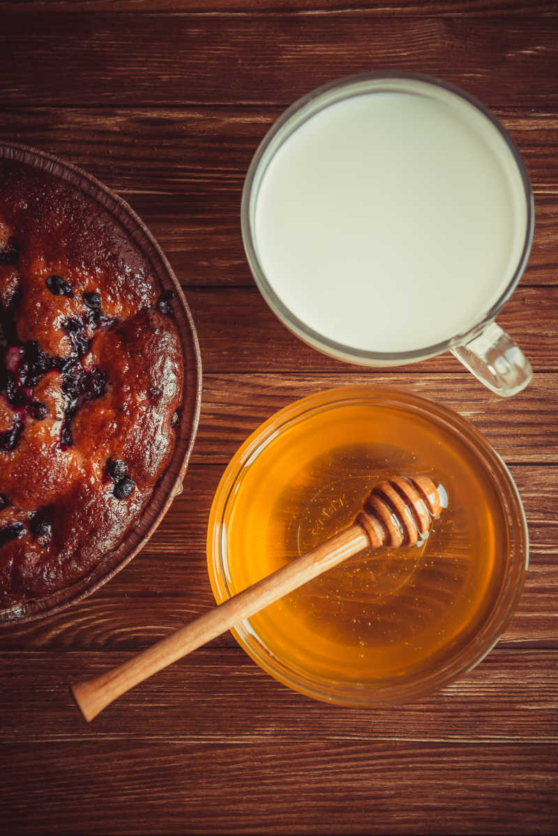 木桌上的蜂蜜蛋糕与牛奶