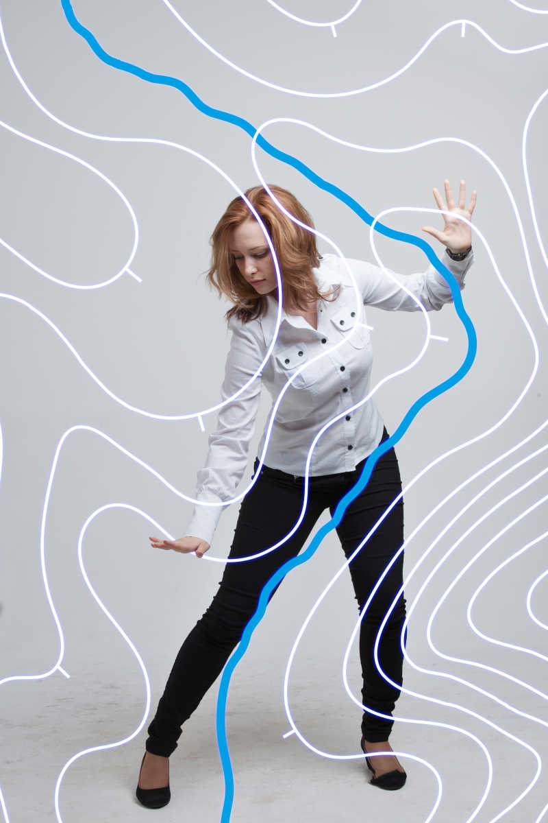 灰色背景上站着用双手触摸虚拟屏幕的女科学家