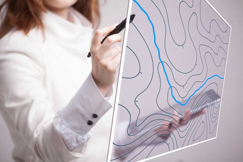 女科学家拿着平板电脑和手写笔在透明屏幕上工作