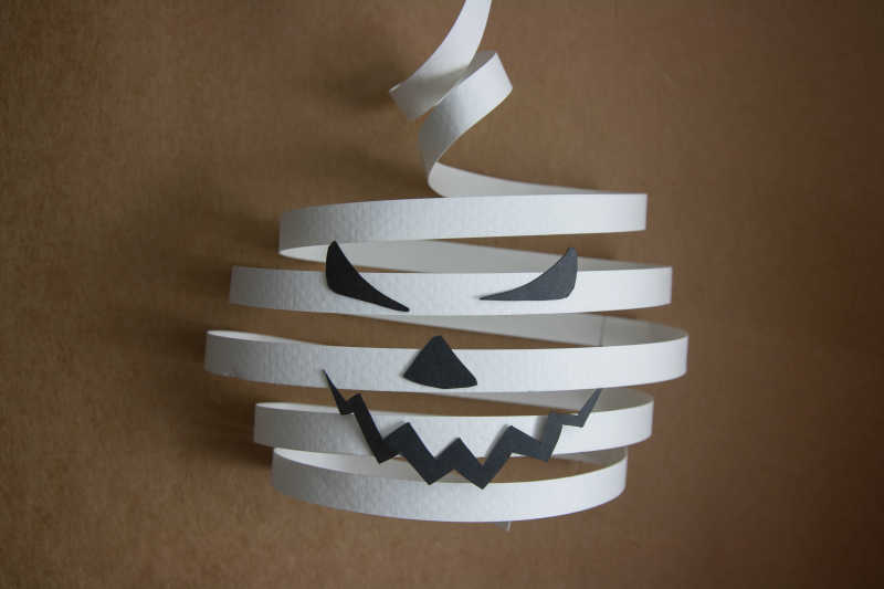 棕色背景上白色的纸质南瓜灯