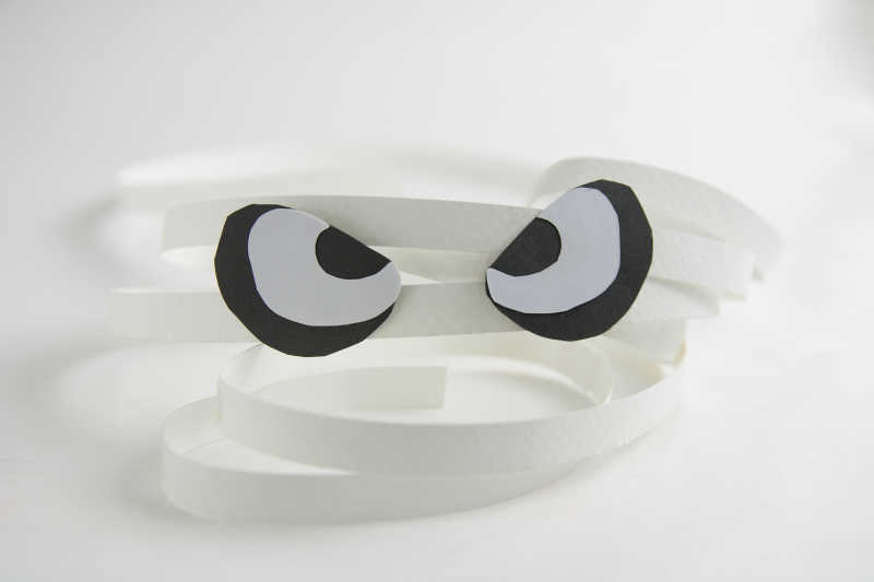 白色背景上贴着眼睛图案的白色长纸条