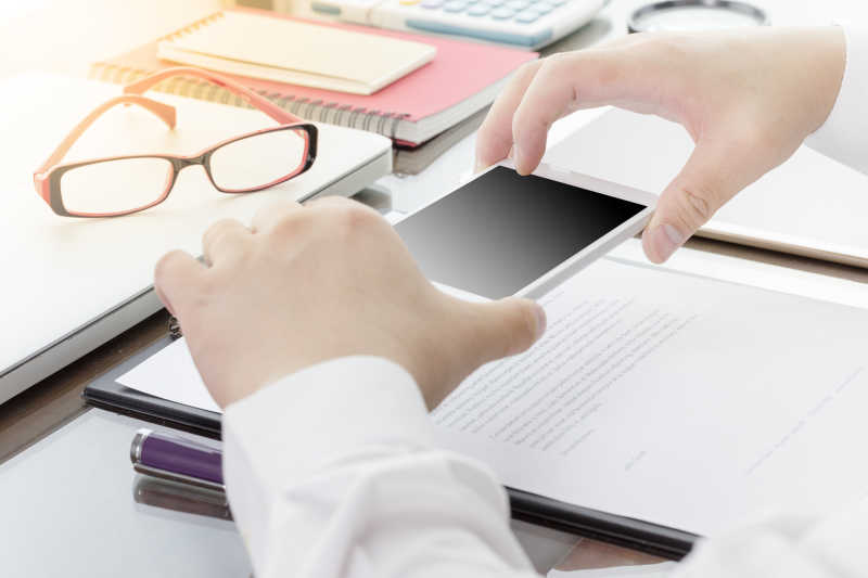 商人使用智能手机拍文件