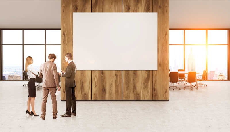一群站在办公室白墙前的商人
