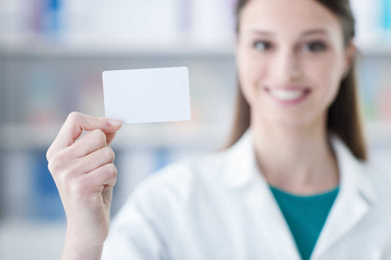 微笑的年轻女医生拿着空名片