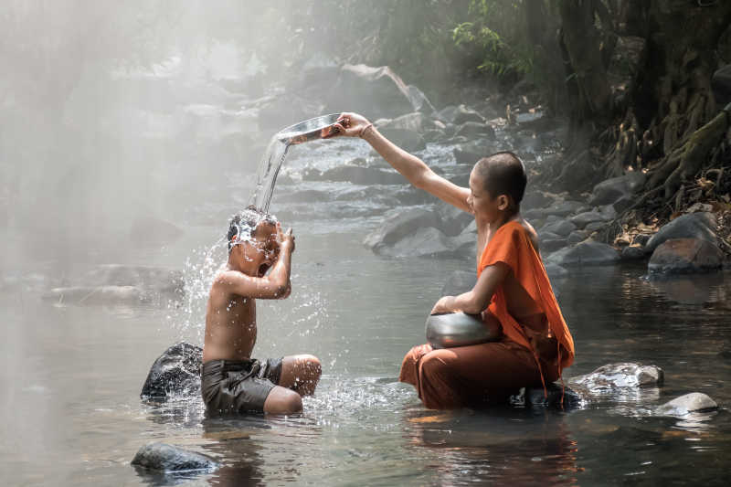 和尚和小伙子在溪边嬉戏玩耍