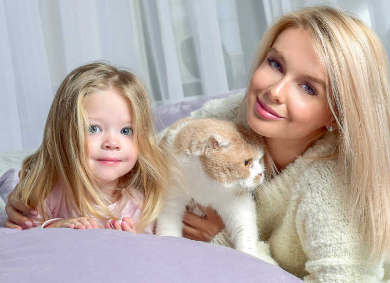 沙发上抱着小猫的母女