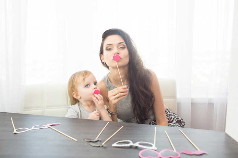 正在和女儿玩纸饰品的母亲