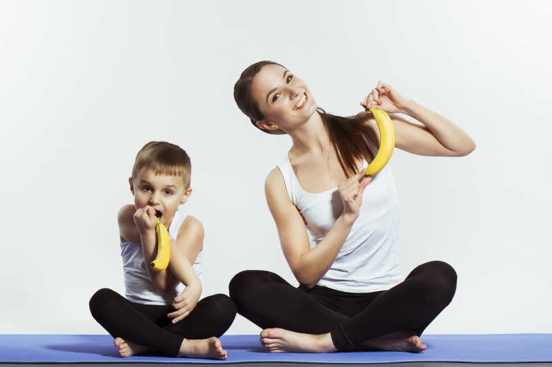 练瑜伽的母子手里拿着香蕉