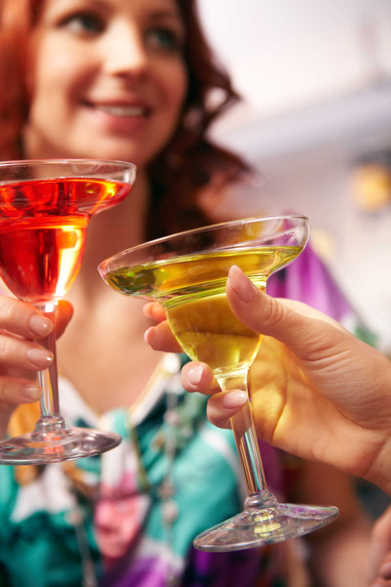 拿着两杯鸡尾酒