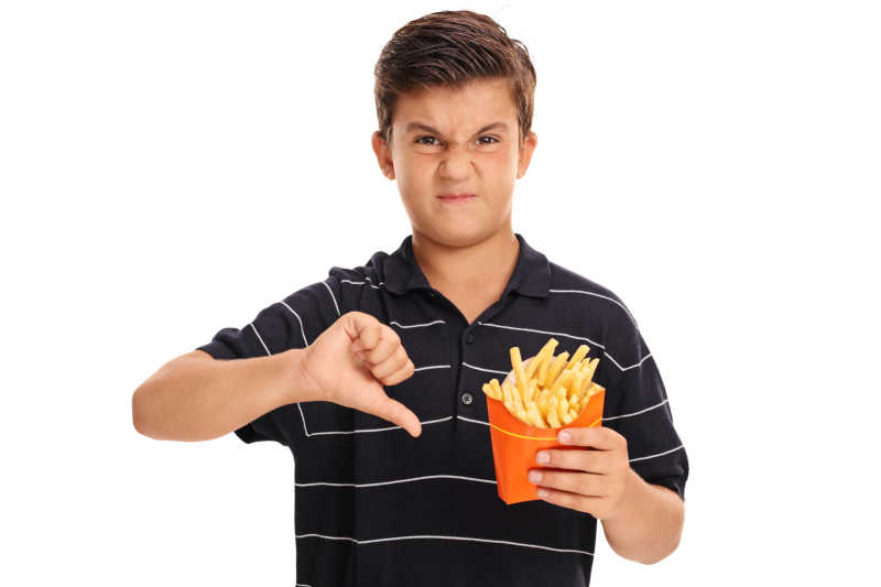 失望的孩子拿着一袋薯条