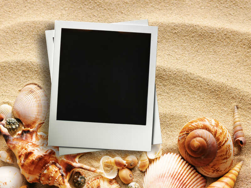 沙滩背景上的一叠拍立得照片