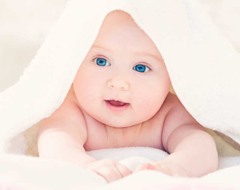 白色毯子下可爱的宝宝