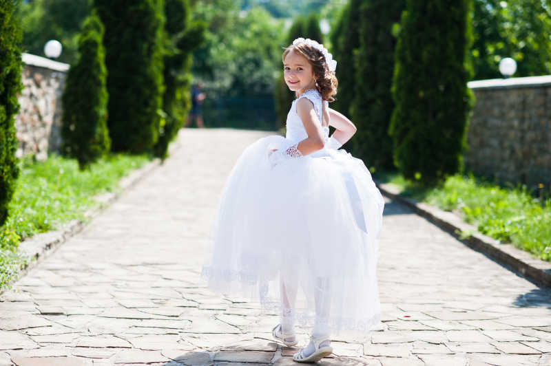 提着白色纱裙走路的小女孩