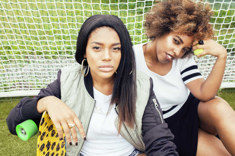 漂亮的坐在网球场上的年轻女孩