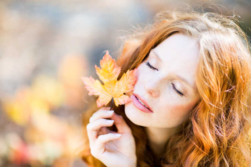 秋季美女拿着枫叶