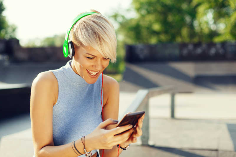 通过智能手机听音乐的短发美女