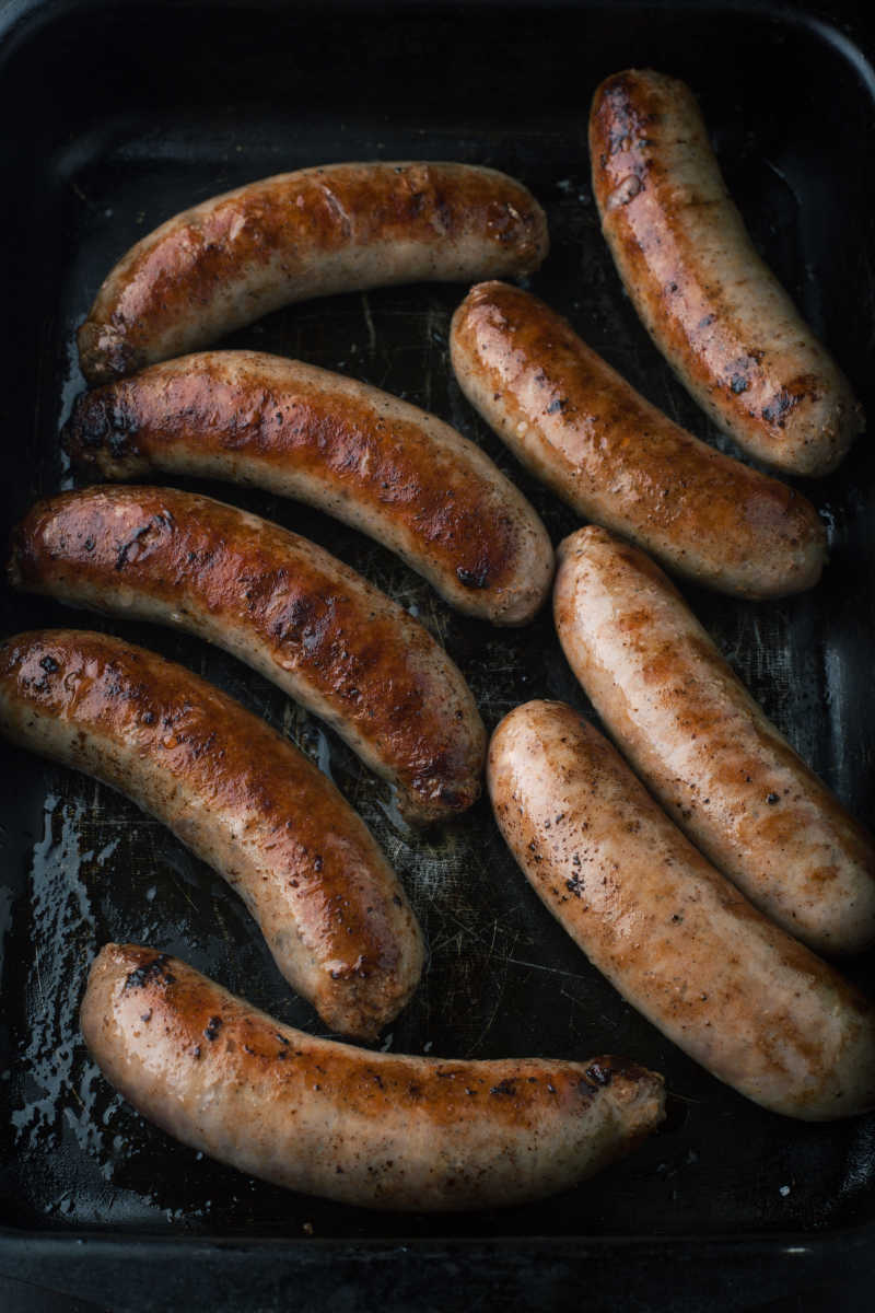 黑色背景上的烤猪肉香肠