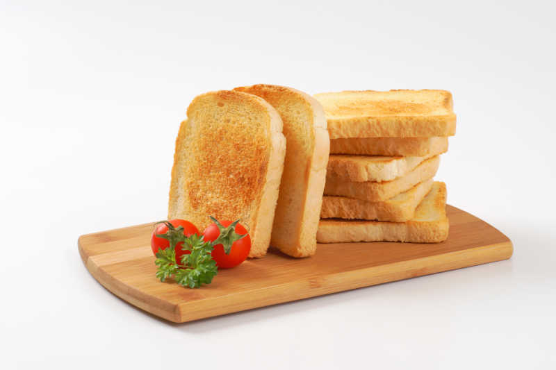 白色背景下砧板上的烤面包